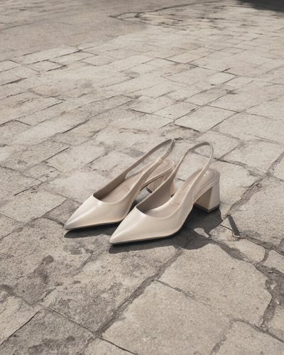 Beige J.Adams Simone slingback heels on stone paving